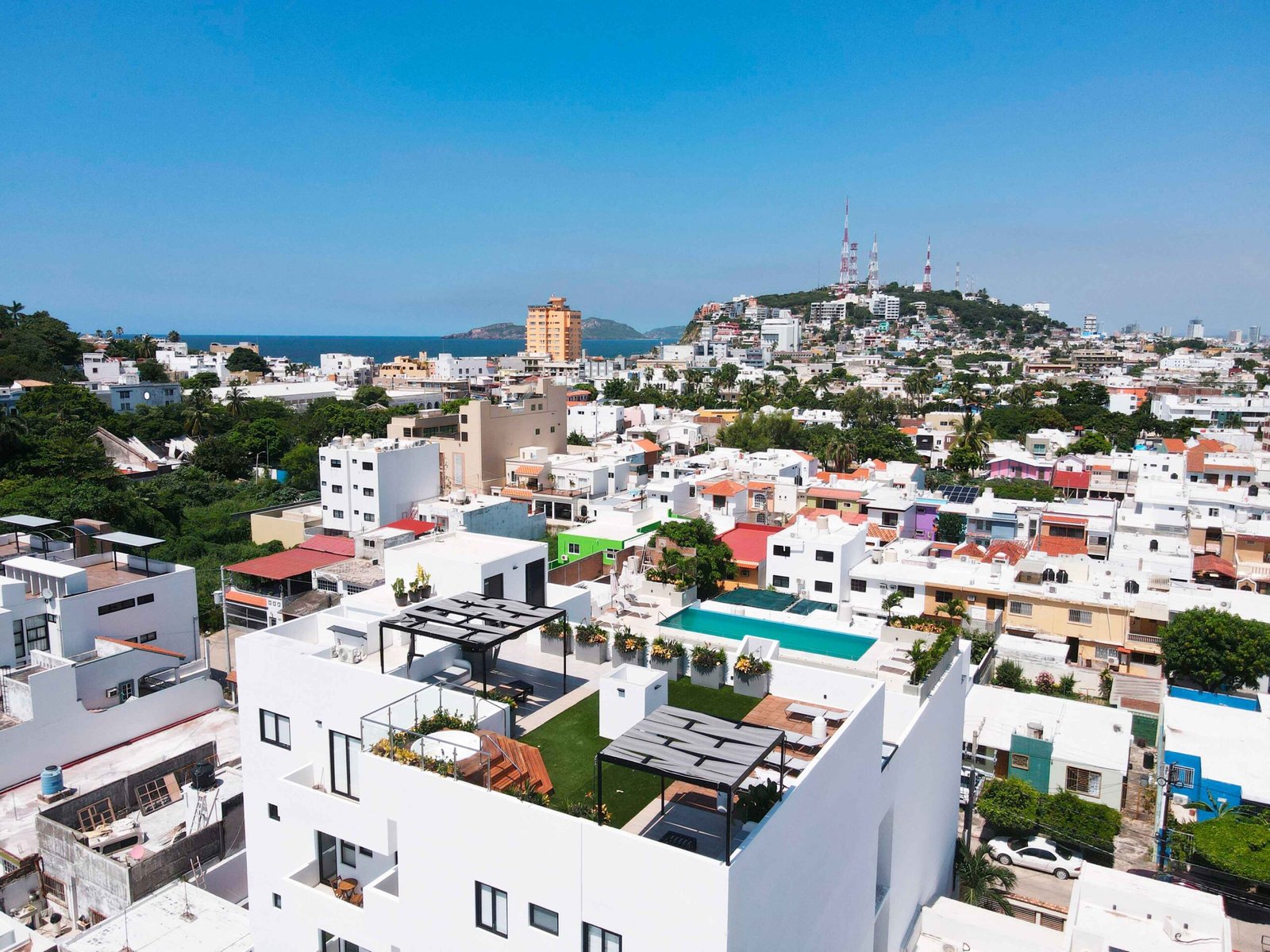 Toma aérea del roof garden de Antara que muestra la alberca, áreas verdes y zonas de descanso.