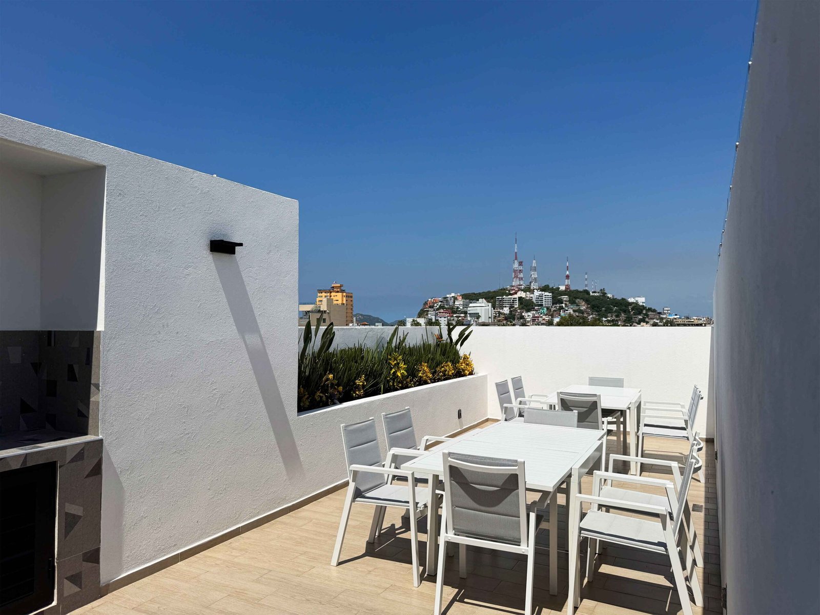 Terraza lounge en Antara con vistas despejadas al cerro y la ciudad bajo un cielo despejado.