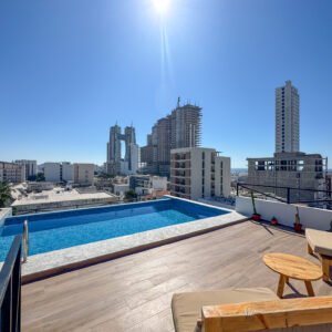 Área recreativa en la azotea con alberca, mobiliario de exterior y vistas espectaculares.