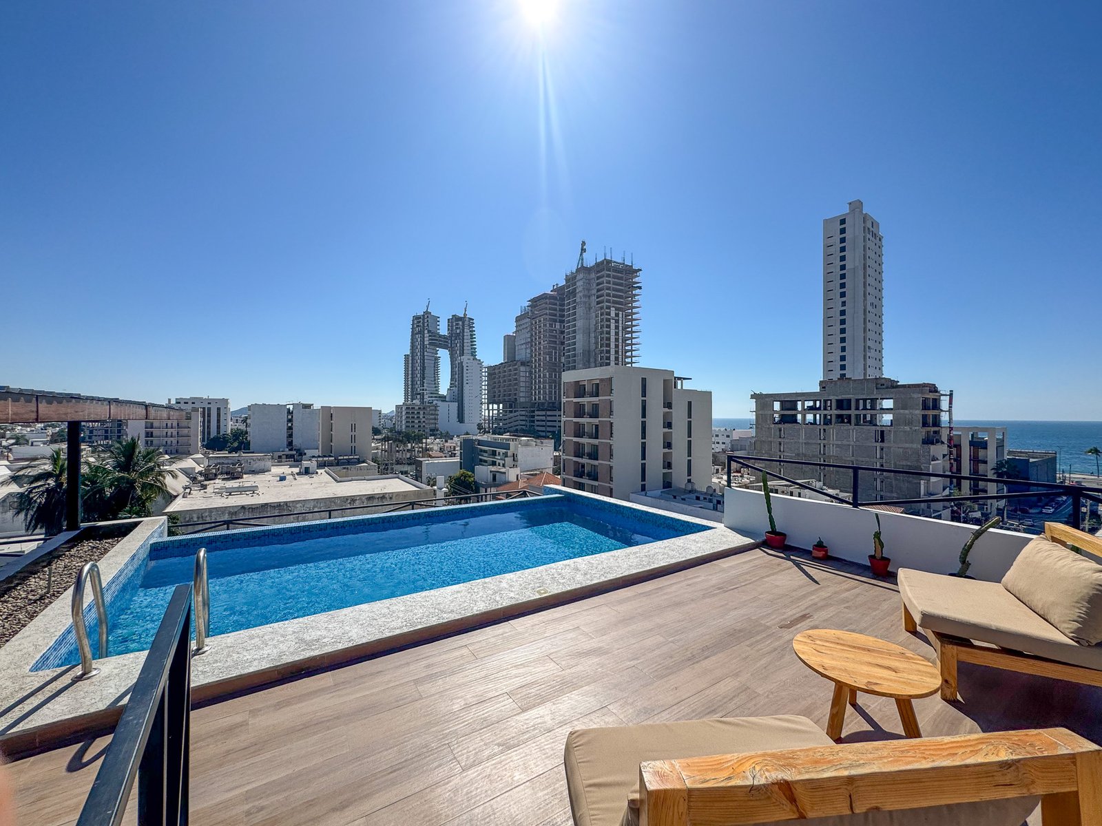 Área recreativa en la azotea con alberca, mobiliario de exterior y vistas espectaculares.