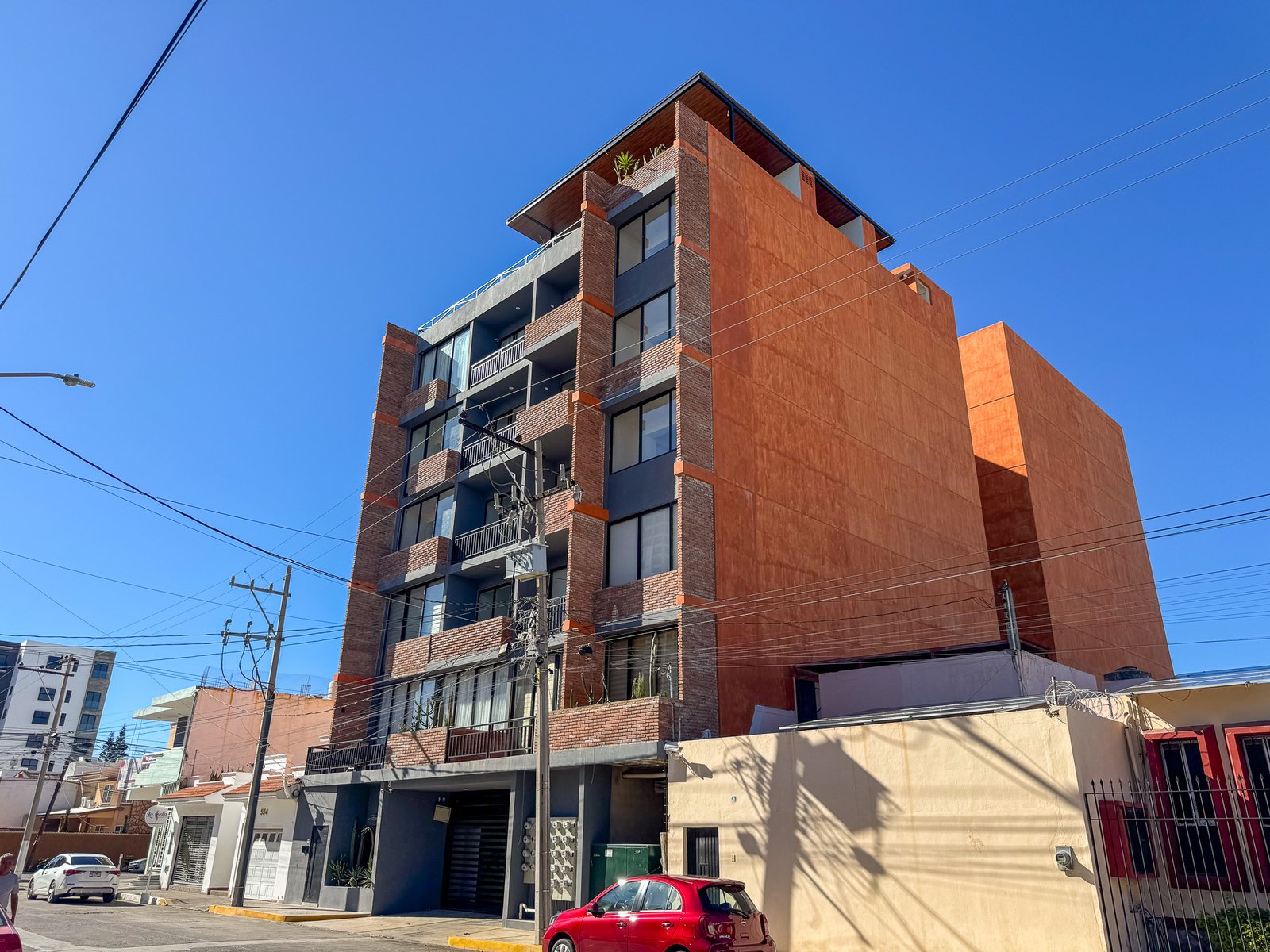 Arquitectura moderna del edificio San Lorenzo en esquina con diseño de ladrillo y balcones en Mazatlán.