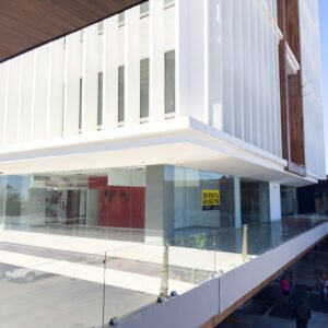 Entrada principal del local comercial F1 con amplios ventanales y acceso desde la terraza.