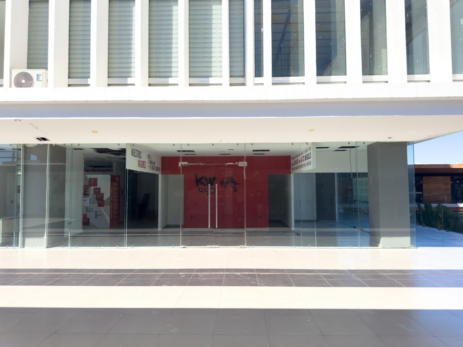 Vista frontal del local comercial en renta F1, destacando su visibilidad y cristales de piso a techo.