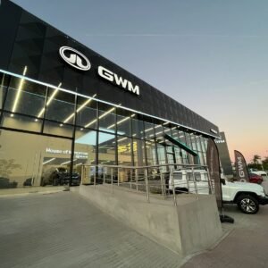 Fachada moderna con rampa de acceso y ventanales de piso a techo.