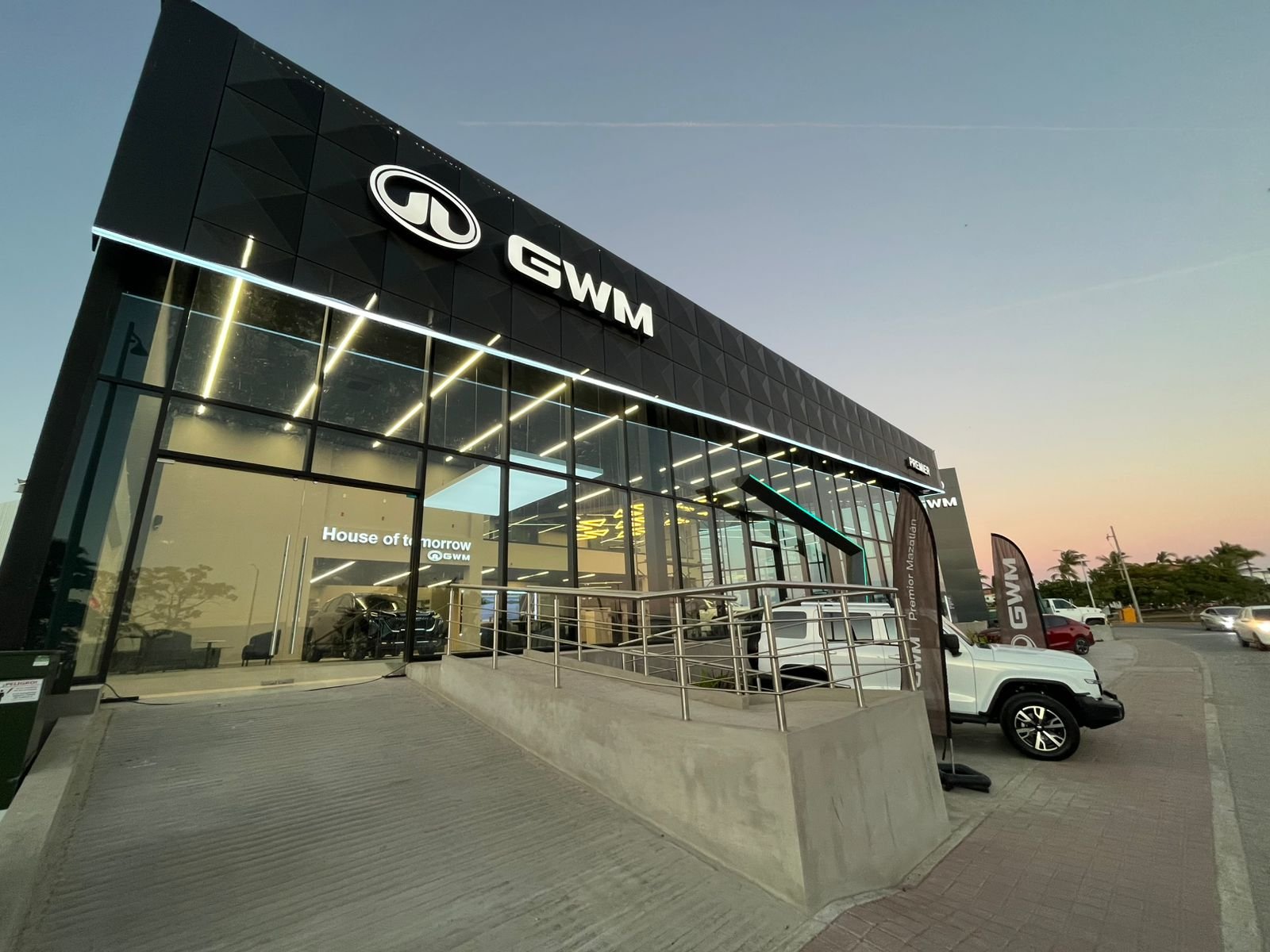 Fachada moderna con rampa de acceso y ventanales de piso a techo.