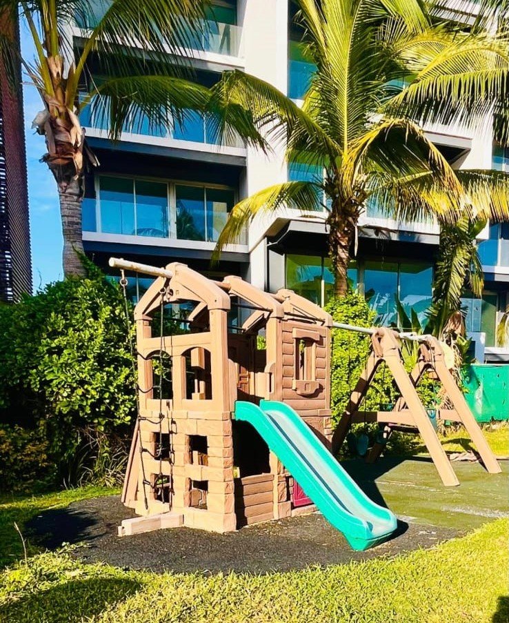 Área de juegos segura para niños ubicada frente a los modernos edificios de departamentos en Manzara.