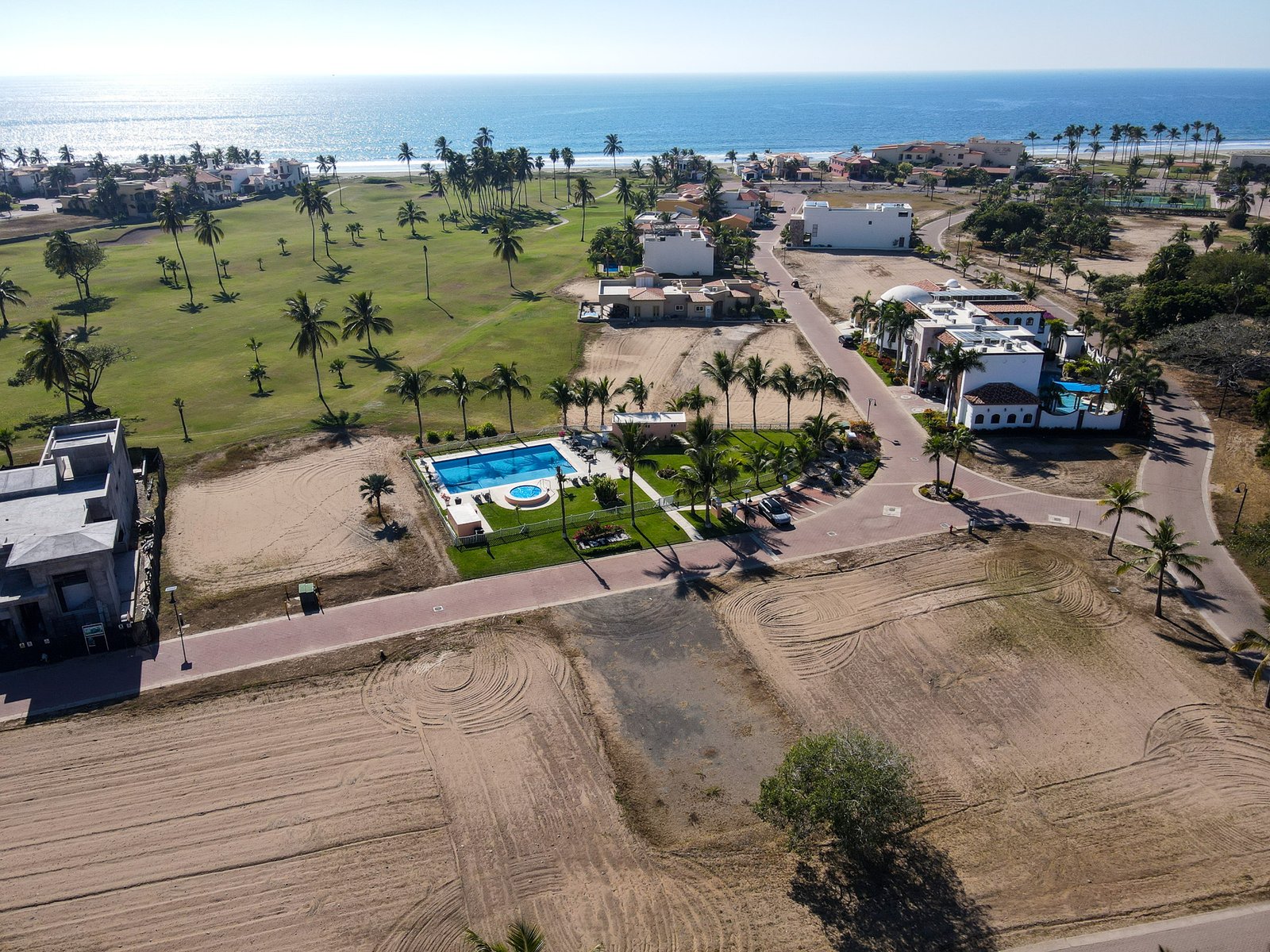 Vista aérea de lote residencial en Estrella del Mar mostrando cercanía con la alberca y el mar.