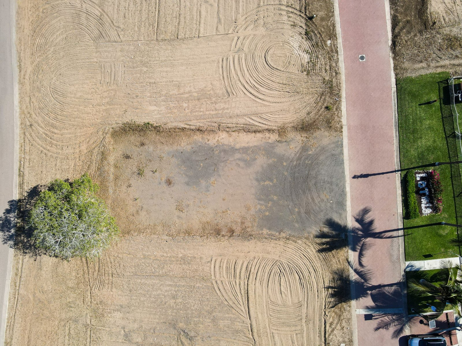 Vista desde arriba de terreno delimitado en el fraccionamiento Estrella del Mar junto a vialidad.