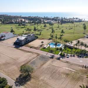 Perspectiva de terreno en venta frente a la casa club con alberca en Estrella del Mar.
