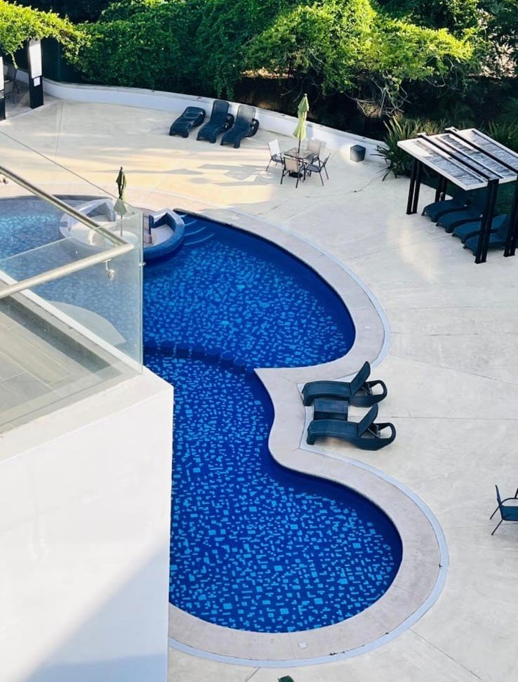 Toma desde las alturas que muestra el diseño orgánico de la alberca y áreas de descanso en Manzara.