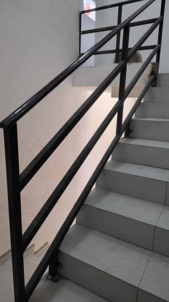 Escaleras metálicas con barandal de seguridad en local comercial en renta.