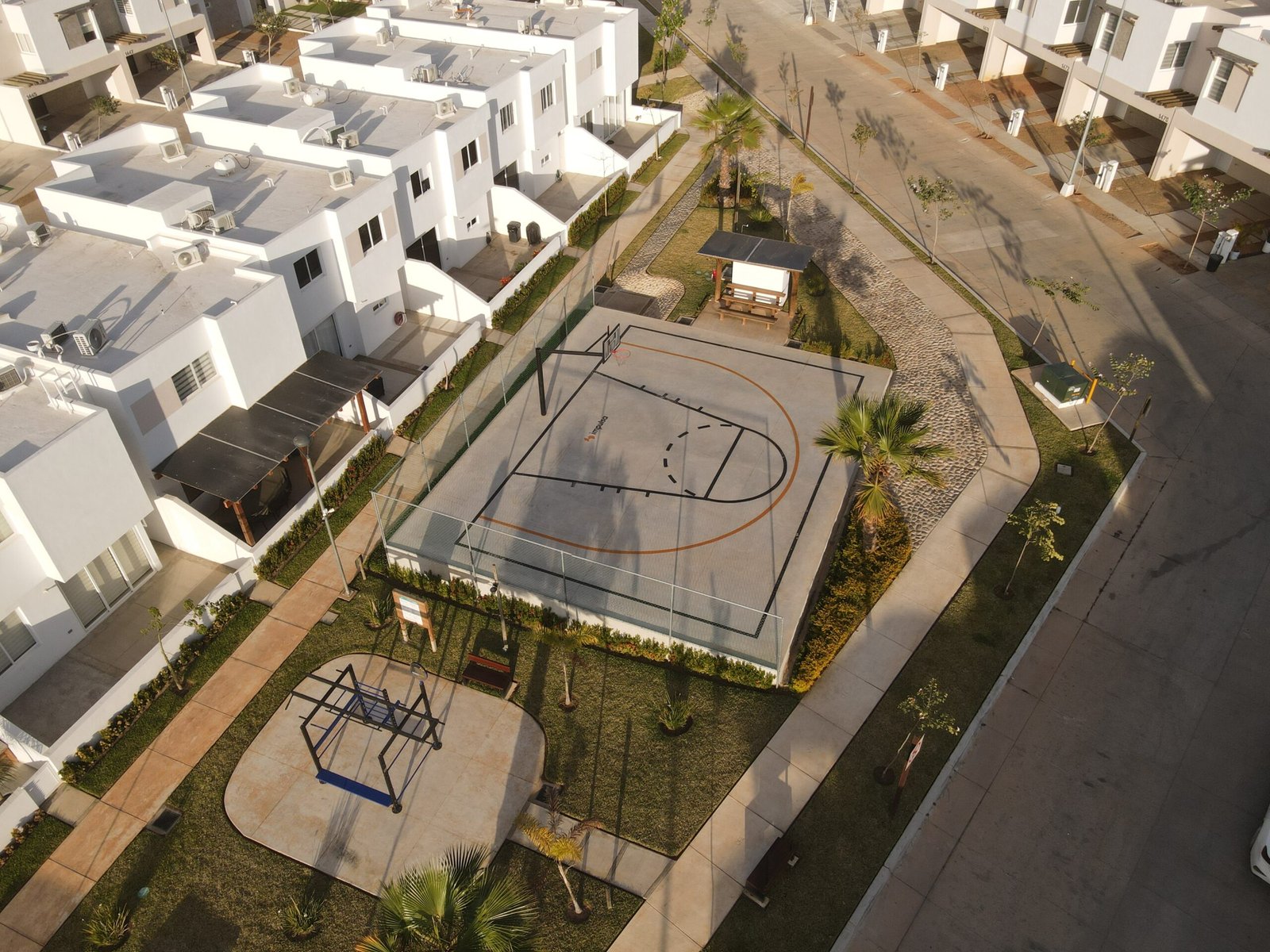Vista aérea de la urbanización que muestra canchas deportivas, áreas verdes y distribución de las residencias en Almarena 1314.